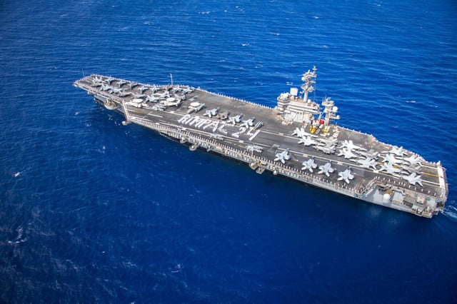Sailors assigned to Nimitz-class aircraft carrier USS Carl Vinson (CVN 70) form "RIMPAC 24" on the flight deck as the ship arrives at Joint Base Pearl Harbor-Hickam for Exercise Rim of the Pacific (RIMPAC) 2024, June 25. (U.S. Navy photo by Mass Communication Specialist 2nd Class Leon Vonguyen)