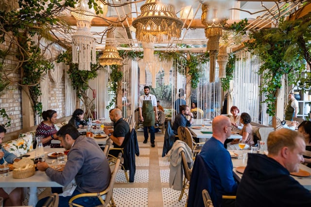 Diners order and enjoy their meals at Copra in San Francisco last year. Restaurant surcharges remain legal in the state, and some patrons aren’t happy. 