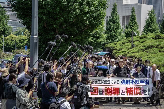 Lawyers and supporters of victims of forced sterilization march toward the Supreme Court of Japan in Tokyo, carrying a banner demanding government apologies and compensation, July 3, 2024.