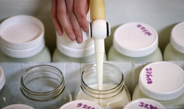 In this March 24, 2017 photo, Zachary Moser fills bottles with raw milk on his parents' Be Whole Again Farm in Excelsior Springs, Mo. It is illegal to sell raw milk for human consumption in Delaware, Hawaii, Iowa, Louisiana, Montana, Nevada, New Jersey and Rhode Island but local food groups, organic farming advocates and libertarians opposing government regulation are fighting to change that. They have succeeded at legalizing raw milk sales in some form in 42 states and wont rest until all states allow it. (AP Photo/Charlie Neibergall)