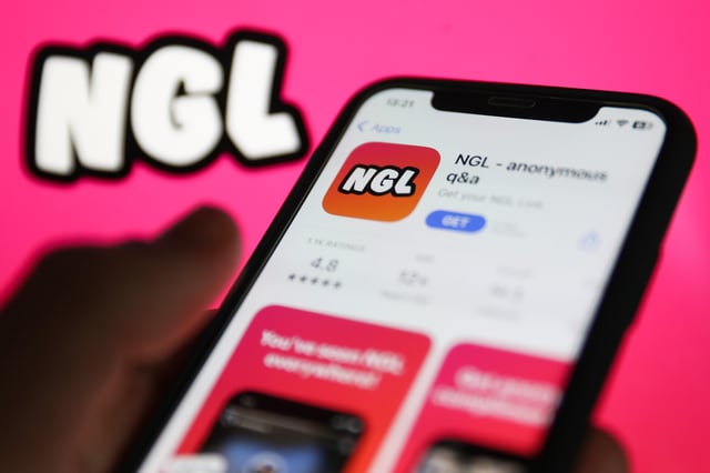 NGL on App Store displayed on a phone screen and NGL website displayed on a screen in the background are seen in this illustration photo taken in Krakow, Poland on January 19, 2023. (Photo by Jakub Porzycki/NurPhoto via Getty Images)