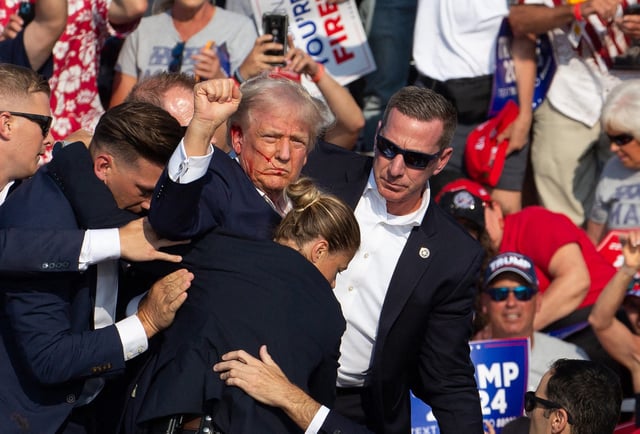 Republican candidate and former President Donald Trump is seen with blood on his face surrounded by U.S. Secret Service agents as he is taken off the stage at a campaign event at Butler Farm Show Inc. in Butler, Pennsylvania on July 13, 2024.