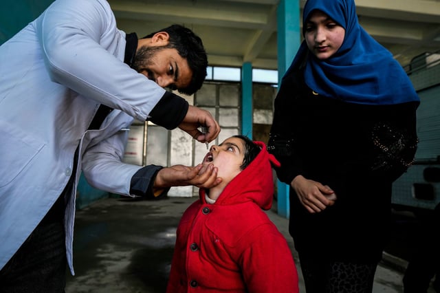 A government health worker administers polio drops to a child in Srinagar, Indian controlled Kashmir, Sunday, Mar. 3, 2024. India eradicated polio more than a decade ago after successfully implementing a polio immunization programme adopted in 1995. (AP Photo/Mukhtar Khan)