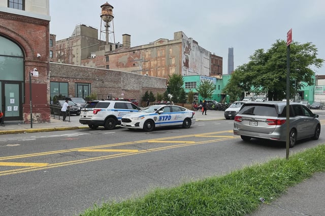 Police cars in front of the Hall Street migrant shelter Monday morning in Clinton Hill, Brooklyn. Two people were shot and killed nearby the migrant shelter this weekend