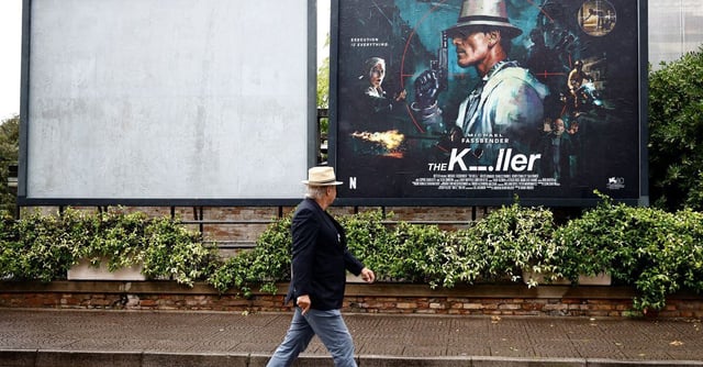 A man walks past a poster for the film "The Killer" on the eve of the opening ceremony of 80th Venice Film Festival, in Venice, Italy, August 29, 2023. REUTERS/Yara Nardi