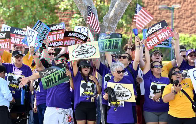 Disney employees rally outside the main entrance of Disneyland Resort in Anaheim, California, on July 17, 2024, ahead of a planned strike authorization vote. More than 200 Disneyland Resort employees protested outside the world-famous California theme parks July 17, calling for better wages and denouncing alleged anti-union practices by the company ahead of a looming strike vote. Featuring workers in costumes from the parks' "Indiana Jones" and "Star Wars" themed rides, among others, the rally was organized by unions representing some 14,000 Disneyland employees, from rollercoaster operators to candy makers.
