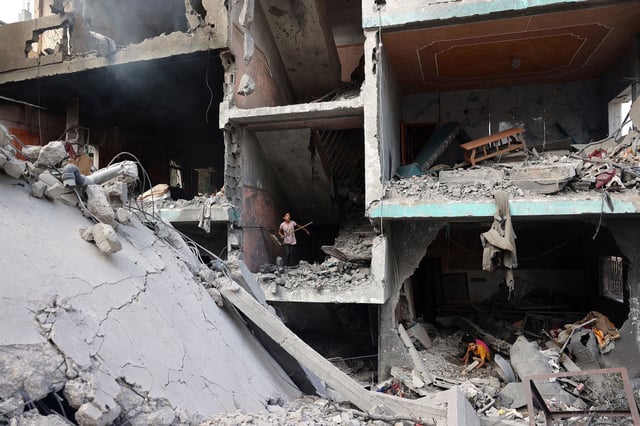 Palestinian children search through the rubble of their home a day after an operation by the Israeli Special Forces in the Nuseirat camp, in the central Gaza Strip on June 9.