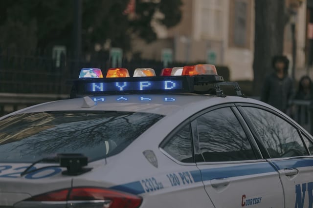 Police have charged a man they say shot two people in front of a Brooklyn migrant center.