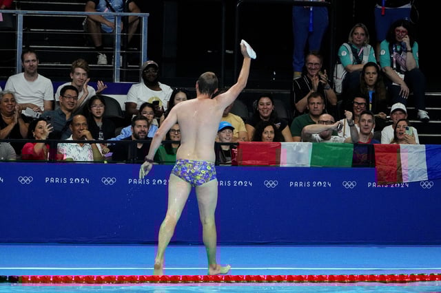 Jul 28, 2024; Nanterre, France; The crowd cheers for a man who retrieved Emma Weber’s (USA) swim cap from the pool during the women’s 100-meter breaststroke preliminary heats during the Paris 2024 Olympic Summer Games at Paris La Défense Arena.