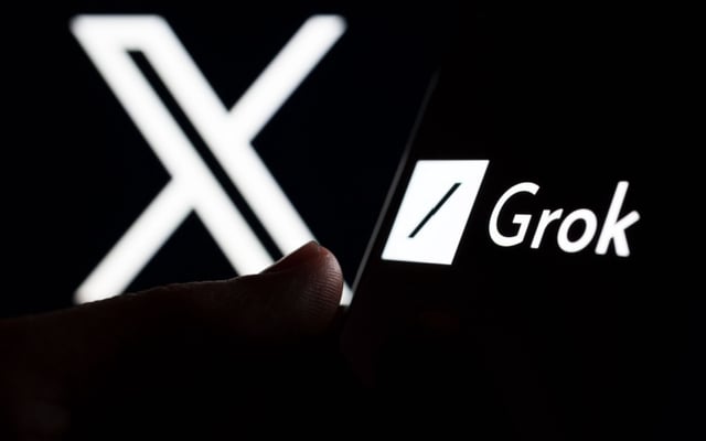 Grok logo seen on smartphone screen and finger pointing at it, with X in the background