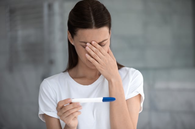 Woman holds pregnancy test