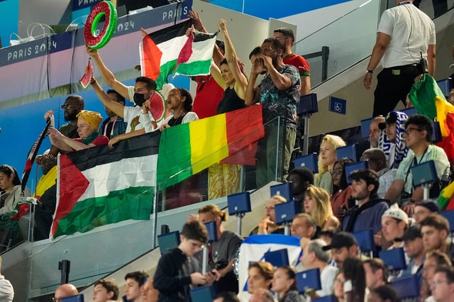 Spectators hold Palestinian flags as they watch the men's group D match between Israel and Mali at the Parc des Princes during the 2024 Summer Olympics on July 24 in Paris.