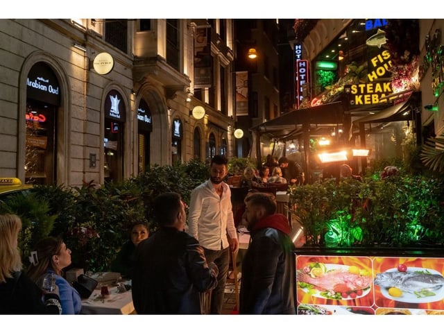 A waiter greets customers at a restaurant on Istiklal Street in Istanbul, Turkey, on Sunday, May 12, 2024. Turkey is working on a plan to set different natural gas and electricity tariffs for different income groups, according to a senior official with knowledge of the matter.