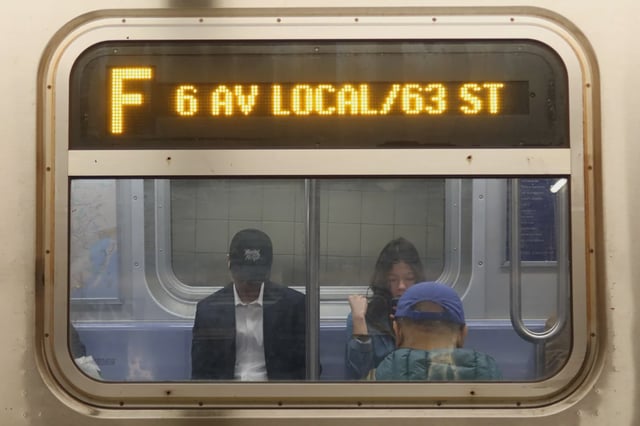 People sit on an F train in April.