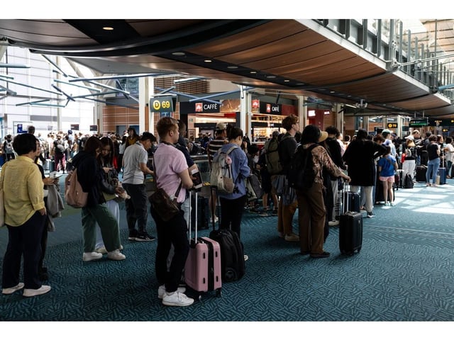 Travelers wait in line to board a flight at Vancouver International Airport (YVR) in Vancouver, British Columbia, Canada, on Thursday, July 11, 2024. The broadening of the disinflation process stalled out in June with prices in the discretionary services categories, such as restaurants, hotels, and air travel, all increasing.