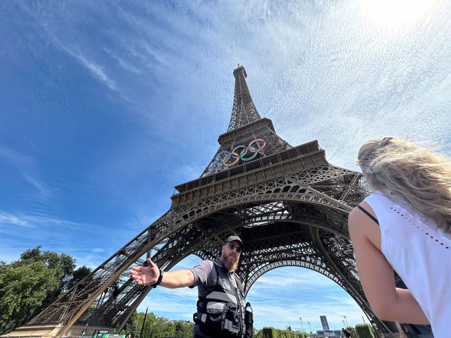 Police evacuate the area around the Eiffel Tower after a man was seen climbing the historic landmark, during the 2024 Summer Olympics, Sunday, Aug. 11, 2024, in Paris France.