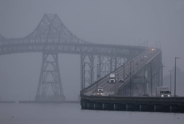 cars drive through either fog or smog on an overpass