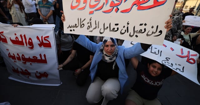 A woman holds a sign protesting women being deprived of their rights in marriage in Tahrir Square, Baghdad, Iraq, August 8, 2024.
