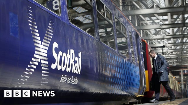 A passenger boarding a ScotRail train