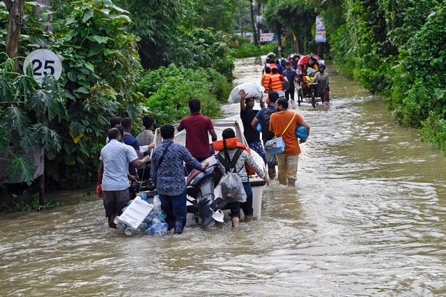 Volunteers take a motor boat to rescue people stranded in flooded residential areas in Feni, a coastal district in southeast Bangladesh, on Saturday. Photo: AP