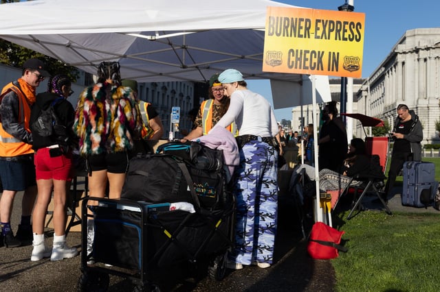 Individuals check in for buses going to Burning Man at Civic Center Plaza on August 25, 2024 in San Francisco, California. Tickets to Burning Man were still on sale days before the multi-day event.