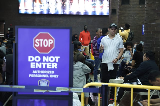 Newly arrived migrants wait to be transferred to shelters from the Port Authority Bus Terminal in New York City on May 15, 2023.