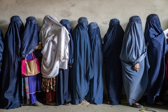 Afghan women wait to receive food rations distributed by a humanitarian aid group, in Kabul, Afghanistan, May 23, 2023. The Taliban Virtue and Vice Ministry had on May 7, 2022 ,said women in public must wear all-encompassing robes and cover their faces except for their eyes. (Ebrahim Noroozi - File / AP)