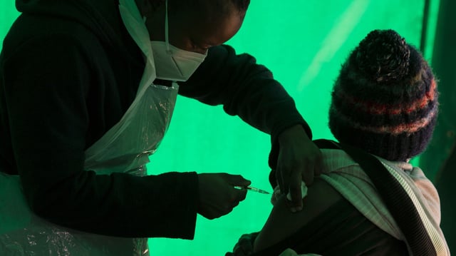 An elderly patient receives a dose of a COVID-19 vaccine at a clinic at Orange Farm, near Johannesburg, South Africa, June 3, 2021 (AP photo by Denis Farrell).
