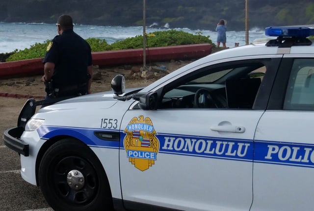 A Honolulu police officer is seen near his cruiser in 2020.