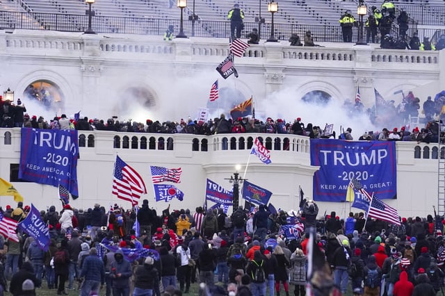 Rioters at the U.S. Capitol on January 6, 2021, in Washington. A former Virginia police officer who stormed the U.S. Capitol has received a reduced prison sentence of six years. Former Rocky Mount Police Sgt. Thomas Robertson's re-sentencing on Wednesday makes him one of the first beneficiaries of a recent U.S. Supreme Court ruling that limited the government’s use of a federal obstruction law. (John Minchillo - File / AP)