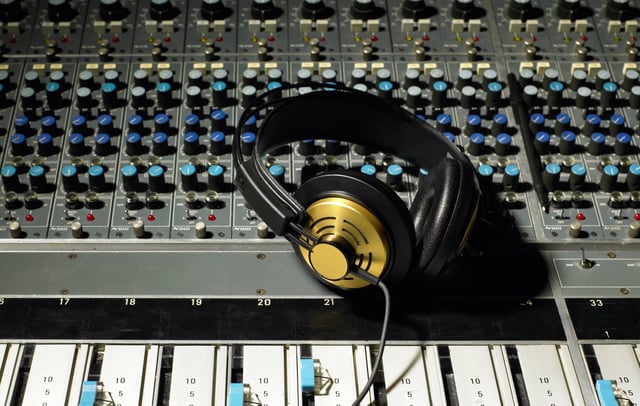 Headphones on a mixing desk. Credit: Image Source