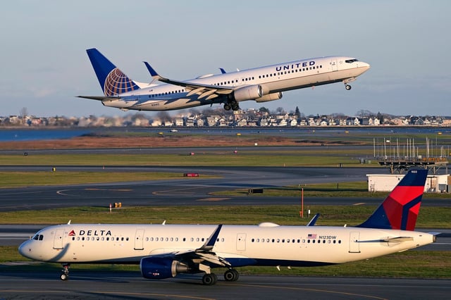 A United Airlines jet takes off while a Delta Airlines plane taxis at Logan International Airport, Monday, Nov. 21, 2022, in Boston. Travel experts say the ability of many people to work remotely is letting them take off early for Thanksgiving or return home later. Crowds are expected to rival those of 2019, the last Thanksgiving before the pandemic. (AP Photo/Charles Krupa)