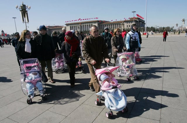Spanish couples take their newly adopted Chinese children for a walk in Beijing's Tiananmen Square, on March 7, 2007.