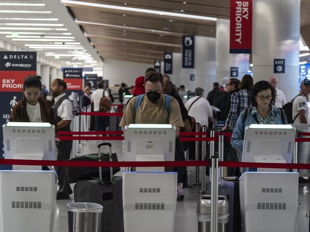 Travelers use kiosks to check in for flights in the Delta Airlines ticketing area at the Los Angeles International Airport in Los Angeles, Friday, Aug. 30, 2024.
