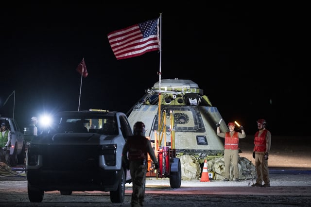 Boeing and NASA teams work around NASA's Boeing Crew Flight Test Starliner spacecraft after it landed uncrewed at White Sands Space Harbor.