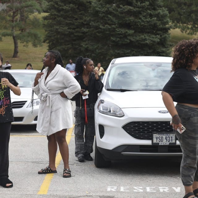 Family members of students at Northwest high school gather and wait for students to be released from the school after a shooting was reported Tuesday, Sept. 10, 2024, in Omaha, Neb. Following a shooting at a Nebraska high school on Tuesday, critically injuring one teen, Omaha police have arrested the suspect about three blocks away from the school.