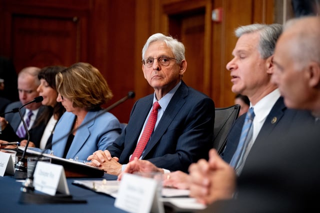 Attorney General Merrick Garland, center listens as FBI Director Christopher Wray speaks during an Election Threats Task Force meeting at the Justice Department in Washington, DC, on September 4, 2024.