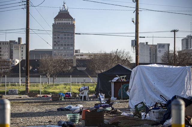 Tents in a homeless encampment line up against a fence in the Chinatown neighborhood just outside of downtown Fresno on Feb. 11, 2022. Photo by Larry Valenzuela for CalMatters
