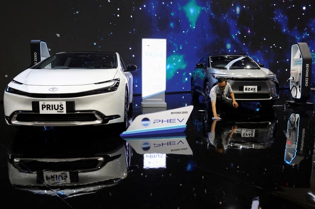 A man wipes the floor near the Toyota Prius PHEV and Toyota BZ4X during the Indonesia International Auto Show in Tangerang, Indonesia, July 18, 2024. REUTERS/Ajeng Dinar Ulfiana/File Photo