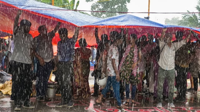 Agitators take cover during rain as junior doctors continued their 'cease work' and sit-in demonstration against the RG Kar Hospital incident outside Swasthya Bhavan in Kolkata. 