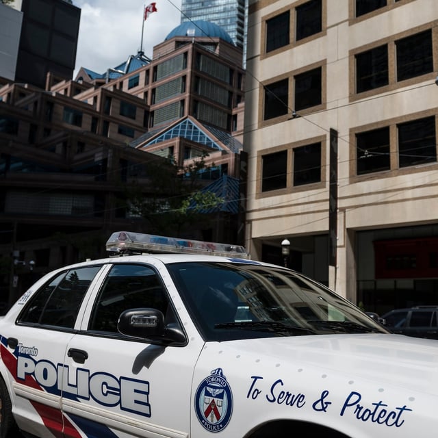 Toronto police say an officer was rushed to hospital after they were slashed in the arm. A police cruiser is parked in front of the Toronto Police Services headquarters, in Toronto, Friday, Aug. 9, 2019. THE CANADIAN PRESS/Christopher Katsarov