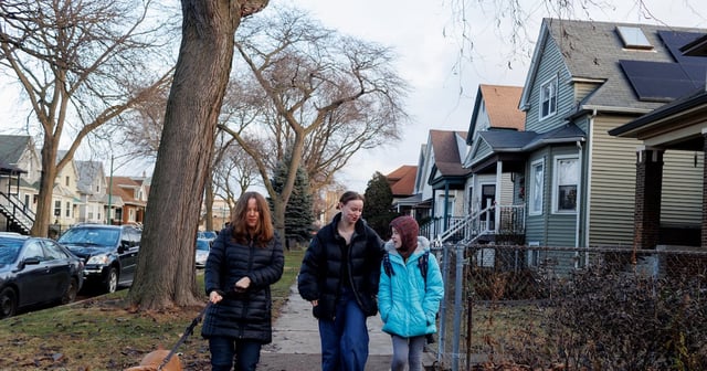 From left to right, Tiffany Harvey walks their dog Mila, alongside her daughters Isabel Harvey, 21, and Amalia Harvey, 10, as they walk Amalia to Haugan Elementary School, a neighborhood school, in Chicago, Ill. on Dec. 18, 2023. Amalia is a fourth grader at Haugan Elementary School in Chicago, Ill.