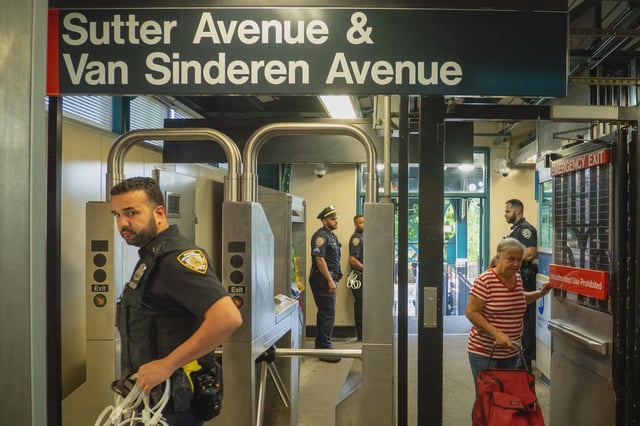 Police are stationed at the Sutter Avenue L train station during a rally two days after the NYPD said officers shot four people there during a fare evasion pursuit.