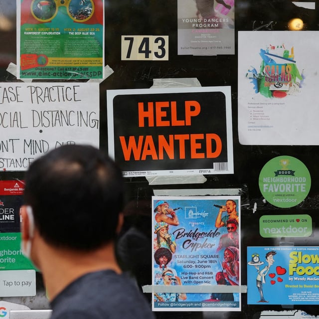 FILE PHOTO: A pedestrian passes a "Help Wanted" sign in the door of a hardware store in Cambridge, Massachusetts, U.S., July 8, 2022. REUTERS/Brian Snyder/File Photo