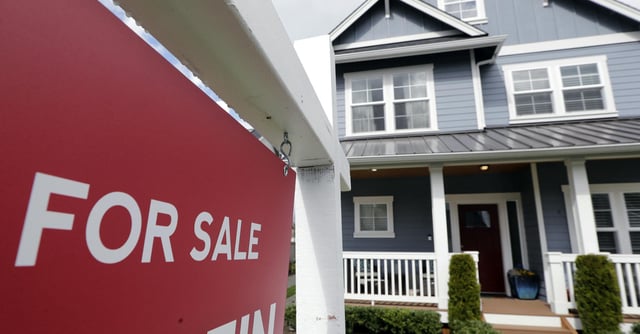 FILE - In this April 1, 2020 photo, a "For Sale" sign stands in front of a home that is in the process of being sold in Monroe, Wash., outside of Seattle. U.S. home sales rose a record-breaking 24.7% in July, extending last month's rebound after the coronavirus pandemic all but froze the housing market this spring, the National Association of Realtors said Friday, Aug. 21, 2020. (AP Photo/Elaine Thompson, File)