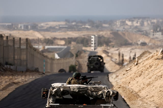 Israeli military vehicles drive through the Philadelphi Corridor area in southern Gaza, amid the ongoing conflict between Israel and the Palestinian Islamist group Hamas in the Gaza Strip, September 13, 2024. REUTERS/Amir Cohen/File Photo