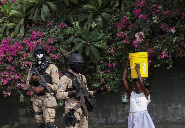 A Haitian police officer talks to a woman while a fellow officer stands guard during a visit of U.S. Secretary of State Antony Blinken, in Port-au-Prince, Haiti September 5, 2024. REUTERS/Ralph Tedy Erol/File Photo/File Photo