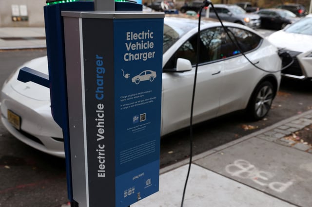 A electric vehicle charger is seen as a vehicle charges in Manhattan, New York, U.S., December 7, 2021. REUTERS/Andrew Kelly/File Photo
