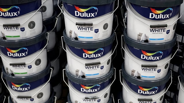 Cans of Dulux paint, an AkzoNobel brand, are seen on the shelf of a DIY retail store in Manchester, Britain.